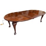 An Edwardian mahogany D-end extending dining table with two spare leaves, the moulded top above a