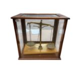 Set of 20th century brass chemical balance scales in a glazed mahogany case.