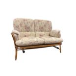 Ercol three piece suite with loose floral cushions
