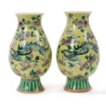 Pair of Chinese famille jaune porcelain footed vases, Republic period, decorated with dragons amongs