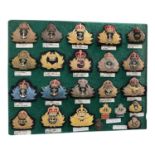 Collection of twenty three Victorian and later Royal Navy badges, mounted on a baize board, (23).