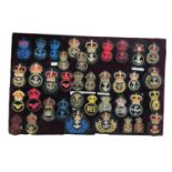 Collection of thirty eight early 20th century and later Royal Navy badges, mounted on a velvet board