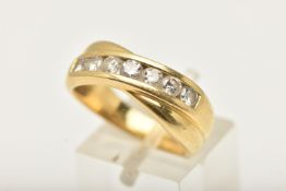 AN 18CT GOLD DIAMOND SEVEN STONE RING, of cross over design set with seven round brilliant cut