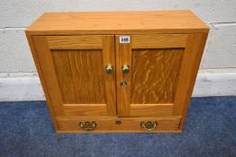 A BENSONS SMALL LIGHT OAK CABINET, the double cupboard doors enclosing four graduated drawers,