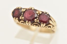 A 9CT GOLD GARNET THREE STONE RING, set with three circular cut garnets, each claw set to a