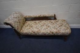 AN EDWARDIAN CHAISE LONGUE, with floral upholstery, raised on turned legs with castors, length 180cm