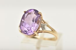 A 9CT GOLD AMETHYST DRESS RING, set with a large oval cut amethyst, in a four claw setting, open