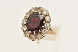 A 9CT GOLD CLUSTER RING, large oval cluster set with a central oval cut garnet, claw set within a
