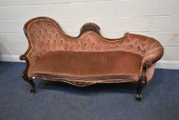 A VICTORIAN CHAISE LONGUE / SOFA, with pink buttoned upholstery. Scrolled armrest, raised on
