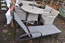 A RATTAN EFFECT GARDEN SET including a 110cm diameter table, glass top in box, four matching chairs,