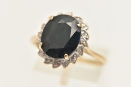 A 9CT GOLD SAPPHIRE AND DIAMOND CLUSTER RING, of an oval form, set with a central oval cut deep blue