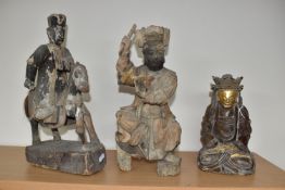 A GROUP OF THREE CHINESE QING DYNASTY CARVED ANCESTRAL VOTIVE FIGURES comprising a figure riding a