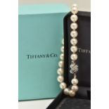 A BOXED 'TIFFANY & CO' CULTURED PEARL BRACELET, individually knotted white pearls with a silver/pink
