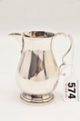 AN ELIZABETH II SILVER MILK JUG, with scrolling handle and leaf pattern, hallmarked 'Moody & Archer'