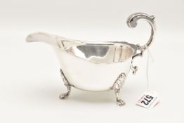 A GEORGE VI SILVER SAUCE BOAT, with wavy rim and scrolling handle, raised on three paw feet with