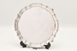 AN ELIZABETH II SILVER WAITER, wavy form raised on four scroll feet, approximate diameter 20cm,
