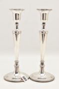 A PAIR OF ELIZABETH II SILVER CANDLESTICKS, polished tapering form with beaded rim, on round