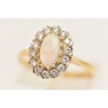 AN OPAL AND DIAMOND RING, an elongated oval opal set with a surround of round brilliant cut