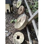 EIGHT VINTAGE QUERN STONES AND TWO WALL MASKS, the stones are of various thicknesses and diameters