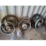 A COLLECTION OF VINTAGE SPOKED MOTORCYCLE WHEELS along with various tyres, including two still