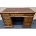 POSSIBLY MAPLE AND CO AN EARLY 20TH CENTURY OAK TWIN PEDESTAL DESK, with a burgundy leather