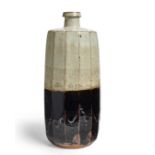 William Marshall (1923-2007)  Tall, cut-sided vase, 1985  Stoneware with rich iron glaze and spe...