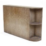 A limed oak headboard, second quarter 20th century, with integrated shelves, 82cm high 121cm wide...