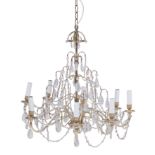 A white metal and cut glass eight-light chandelier, 20th century, the scrolling arms issuing from...