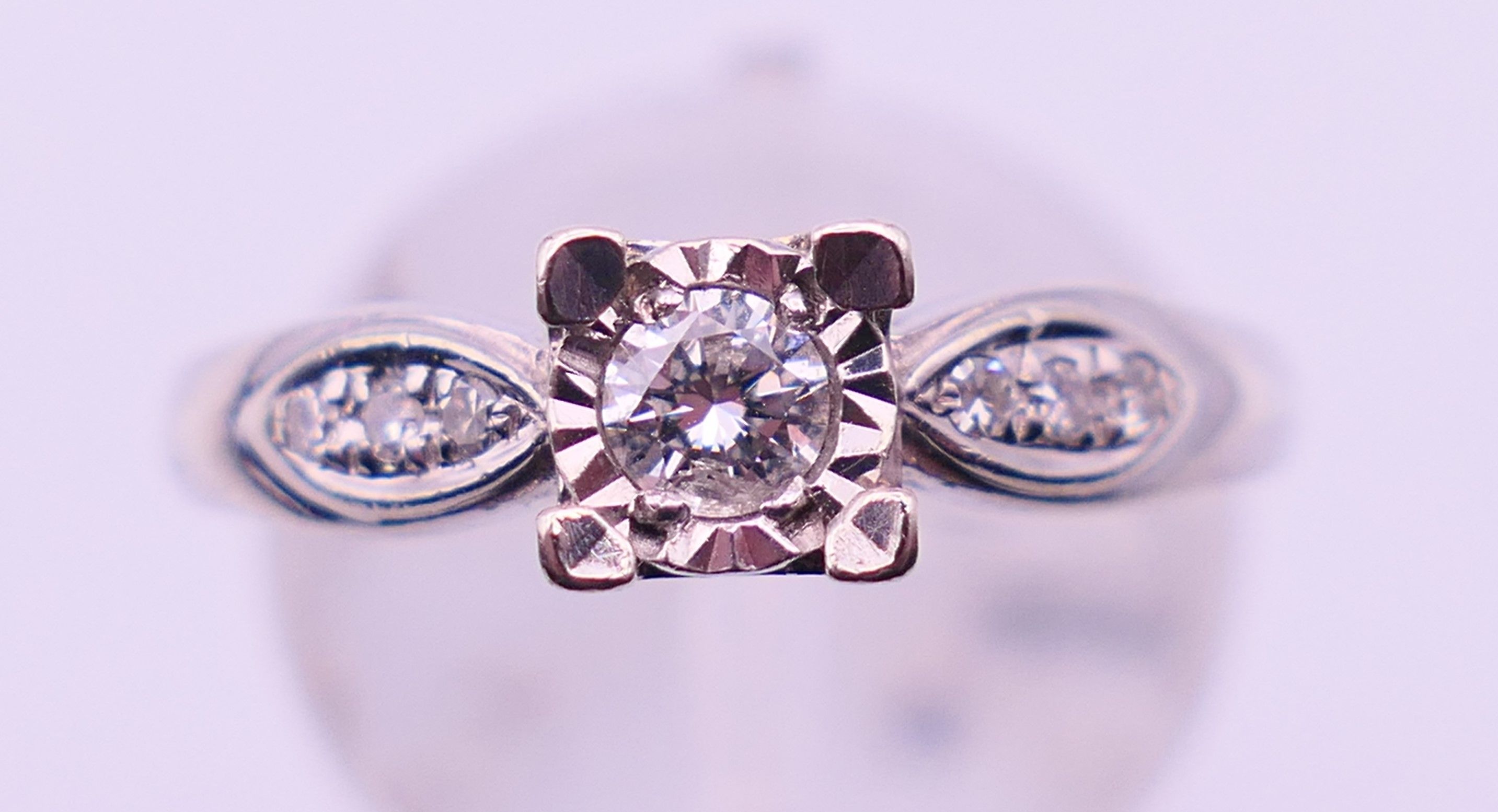 A 9 ct white gold and 0.20 carat diamond ring. Ring size N/O. 2.9 grammes total weight.