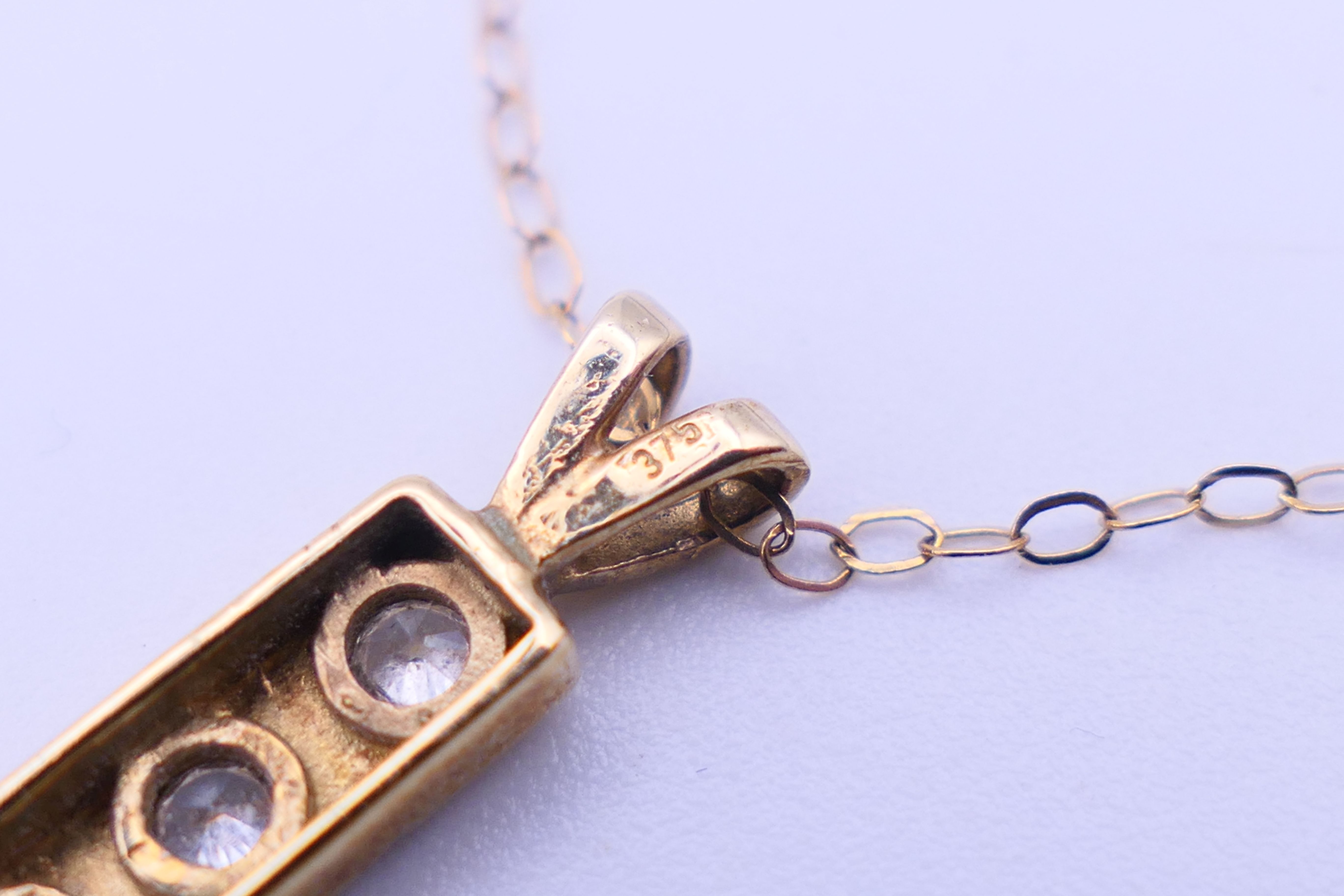 A 9 ct gold three-stone pendant on a 9 K gold chain. Pendant 1. - Image 8 of 8