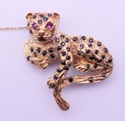 A 9 ct gold, diamond, ruby and sapphire leopard-form brooch. 3.5 cm x 3.5 cm. 11.