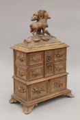 A Black Forest carved wooden jewellery box surmounted with a goat. 39 cm high.