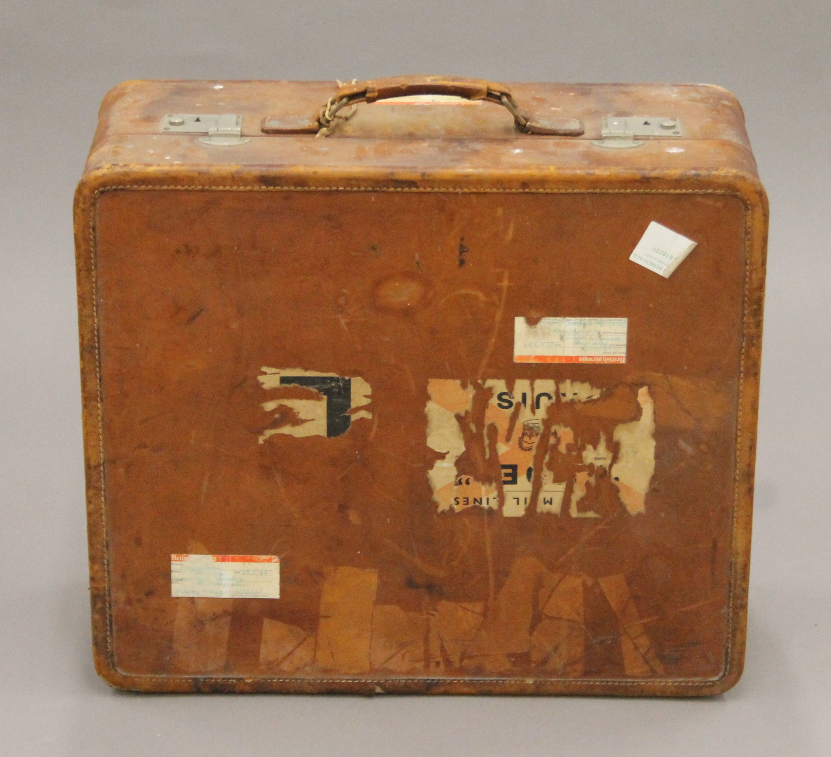 A vintage leather suitcase with some old travel labels. 55 cm wide.