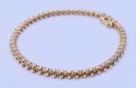 A 14 K gold and diamond tennis bracelet. 18 cm long. 11.2 grammes total weight.