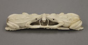 A Japanese Meji Period antler carving of two frogs eating a bug. 15.5 cm long.