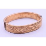 A Victorian chased bangle. 6 cm wide.
