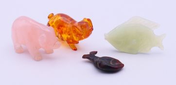 A rose quartz pig, a jade fish, an amber-coloured pig and a carved wood fish. The former 4.