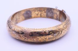 A chased silver gilt bangle. 6 cm wide.