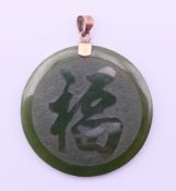 A 14 K gold-mounted jade pendant. 3 cm diameter.
