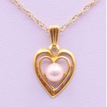 A 9 ct gold and pearl heart pendant on a 9 K gold chain. Pendant 1.