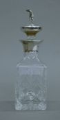 A small silver-topped cut glass decanter surmounted with a golfer. 17 cm high.