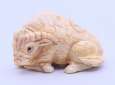 A bone netsuke formed as a buffalo. 5 cm long.
