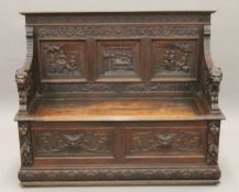 A 19th century carved oak settle. 139 cm wide.