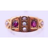 An 18 ct gold, ruby and seed pearl ring. Ring size M. 3.2 grammes total weight.