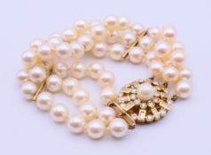 A three-strand pearl bracelet set with a 9 ct gold clasp. 18.5 cm long.