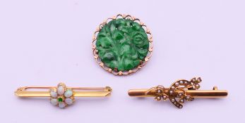 Three gold mounted brooches. The largest 4.5 cm wide. 13.7 grammes total weight.