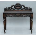 A Victorian carved oak Greenman side table. 106 cm wide.