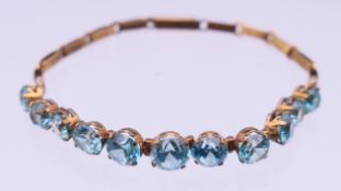 An unmarked gold and blue stone bracelet. 16 cm long. 6 grammes total weight.