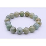 A jade bead bracelet. Each bead approximately 1 cm, bracelet 17 cm long.