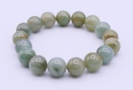 A jade bead bracelet. Each bead approximately 1 cm, bracelet 17 cm long.